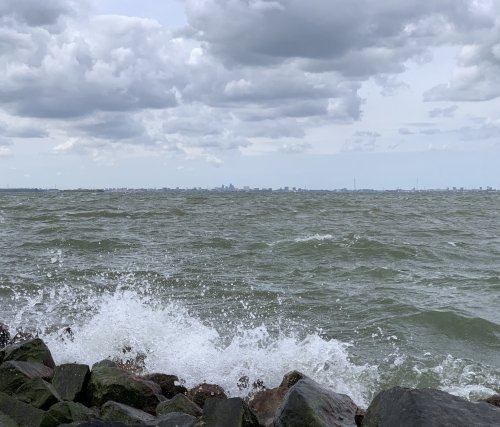 Wind blowing strongly over the water with Amsterdam on the horizon, as seen from Almere