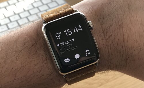 Apple Watch on the wrist showing current temperature, time, heart rate and access to mail, messages and music