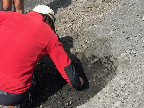 Our guide, Peppe, uncovers some dark patches on the crater. Steam escapes from it - you can literally feel the heat!