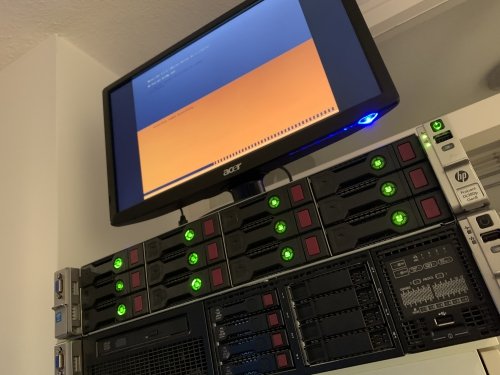 HPE ProLiant DL380p server powered on, green lights indicate the drives are working, monitor is connected and showing the boot process