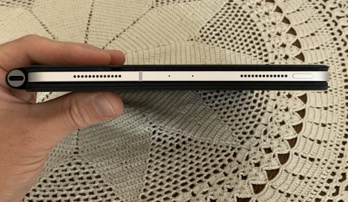 iPad Pro Magic Keyboard as seen from the side, it is thicker and it has a dark aluminium hinge sticking out (on the left side)