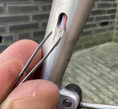 Using a tweezer I eventually succeeded in guiding the wire through the tiny holes in my front fork