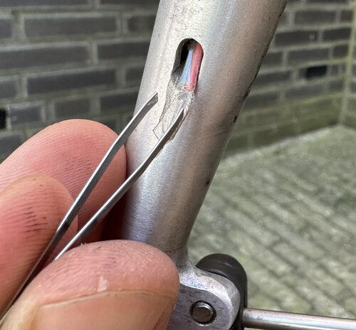 Using a tweezer I eventually succeeded in guiding the wire through the tiny holes in my front fork