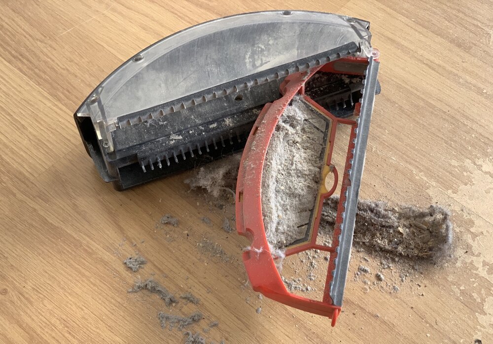 Entfernen Sie Staub aus dem Behälter, indem Sie den Filter herausziehen