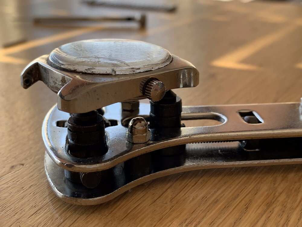 Stellen Sie das Werkzeug so ein, dass es zu den Befestigungspunkten auf dem Gehäuseboden passt, damit es diesen öffnen kann