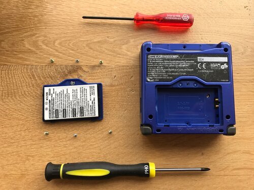 Arrange the screws around something easy to recognise (the battery) to easily keep track of where the (different) screws should