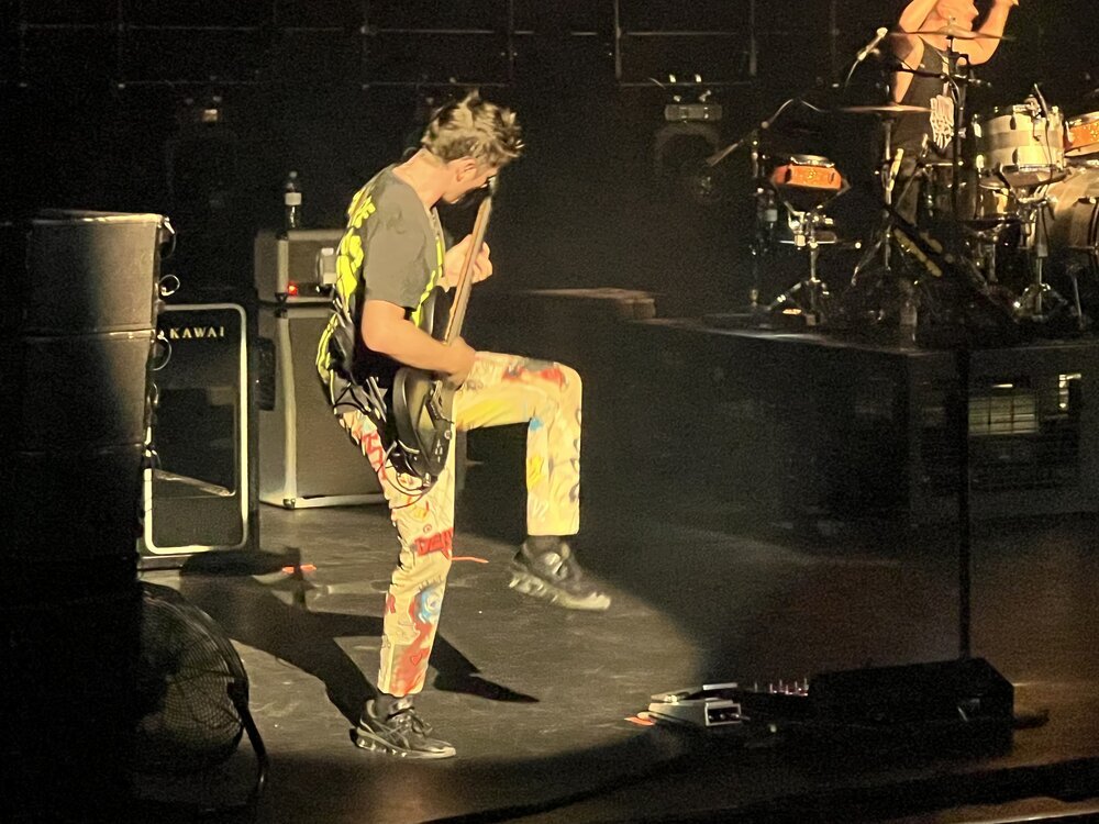 Matthew Bellamy tocando la guitarra - sabes que estás en un teatro pequeño cuando puedes leer el texto en su camisa / pantalones