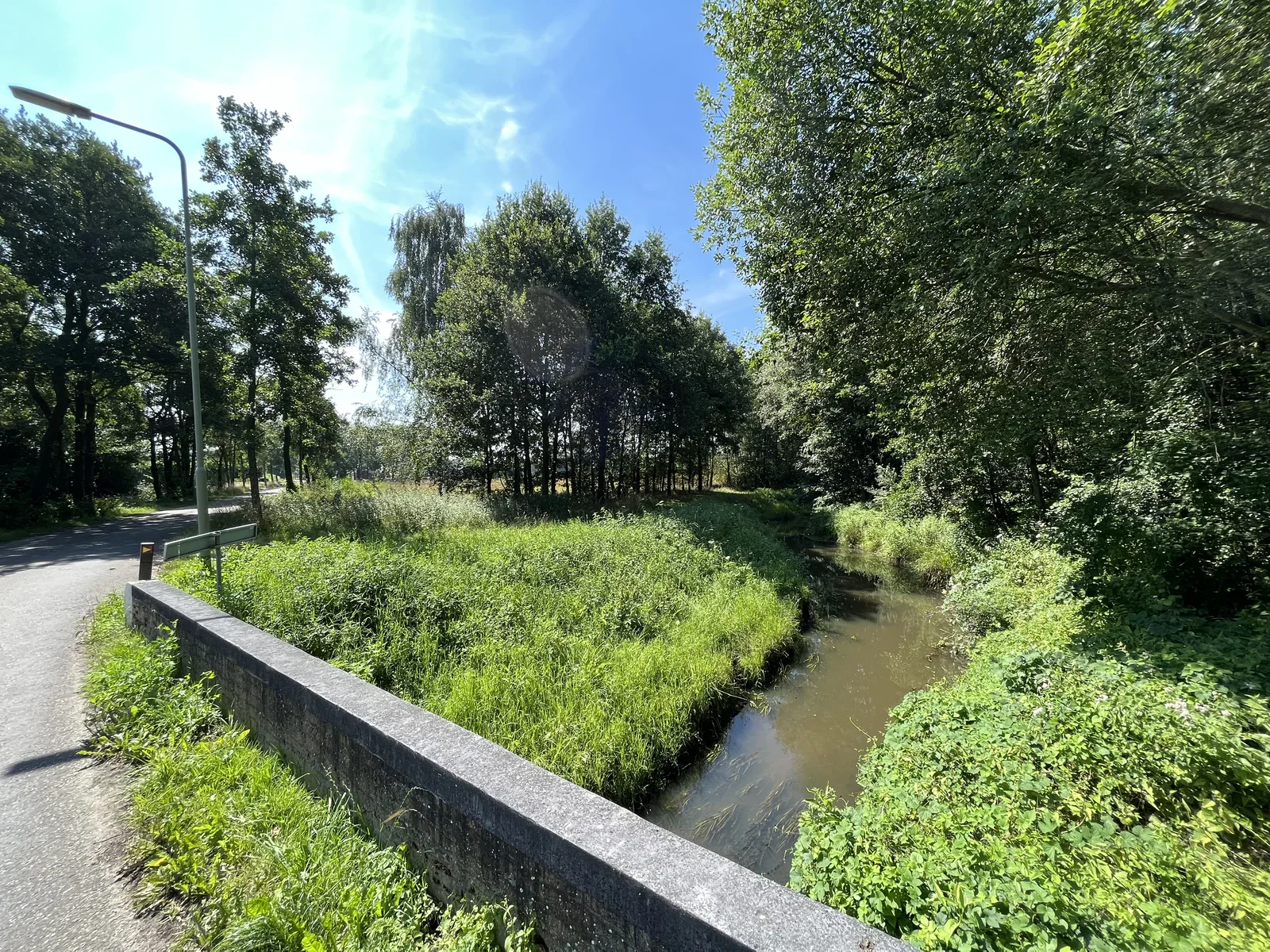 The creek "De Groote Molenbeek" meanders through forests and countryside, a picturesque sight to behold, a typical scene for this region