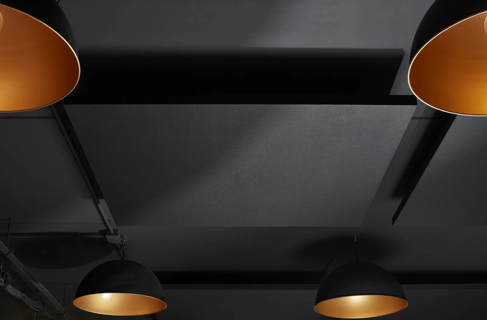A black ceiling with copper-lined pendants. Photo: Kevin Middelkoop