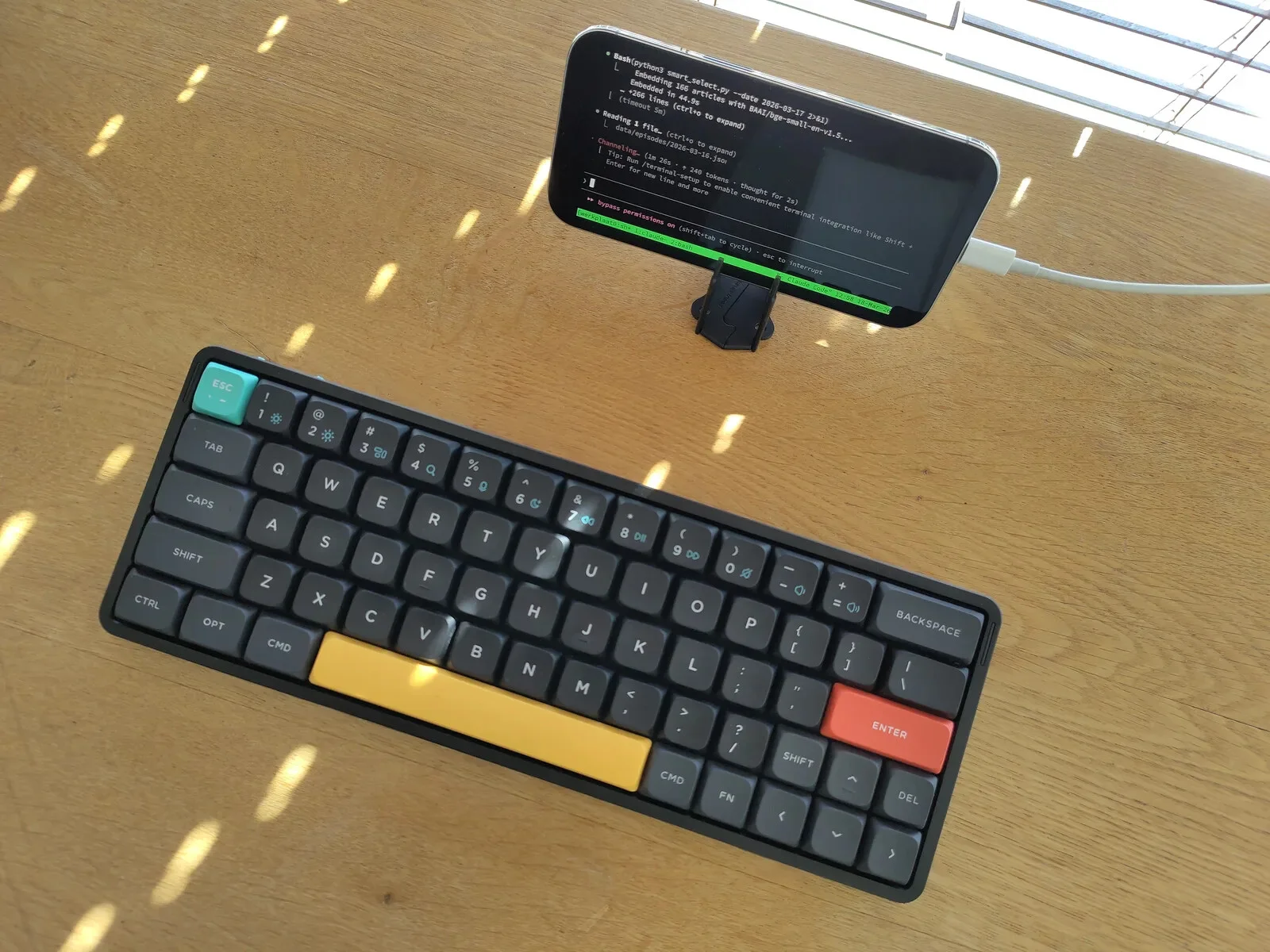 De hele computer van die weken: een toetsenbord en een telefoon op het bureau