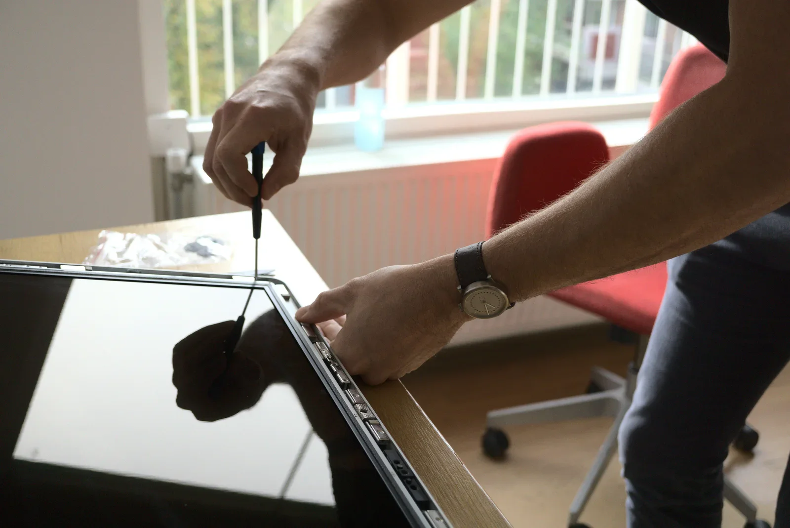 The display is fixed using Torx screws - it can be a little tricky to remove the screws as the magnets easily catch them!