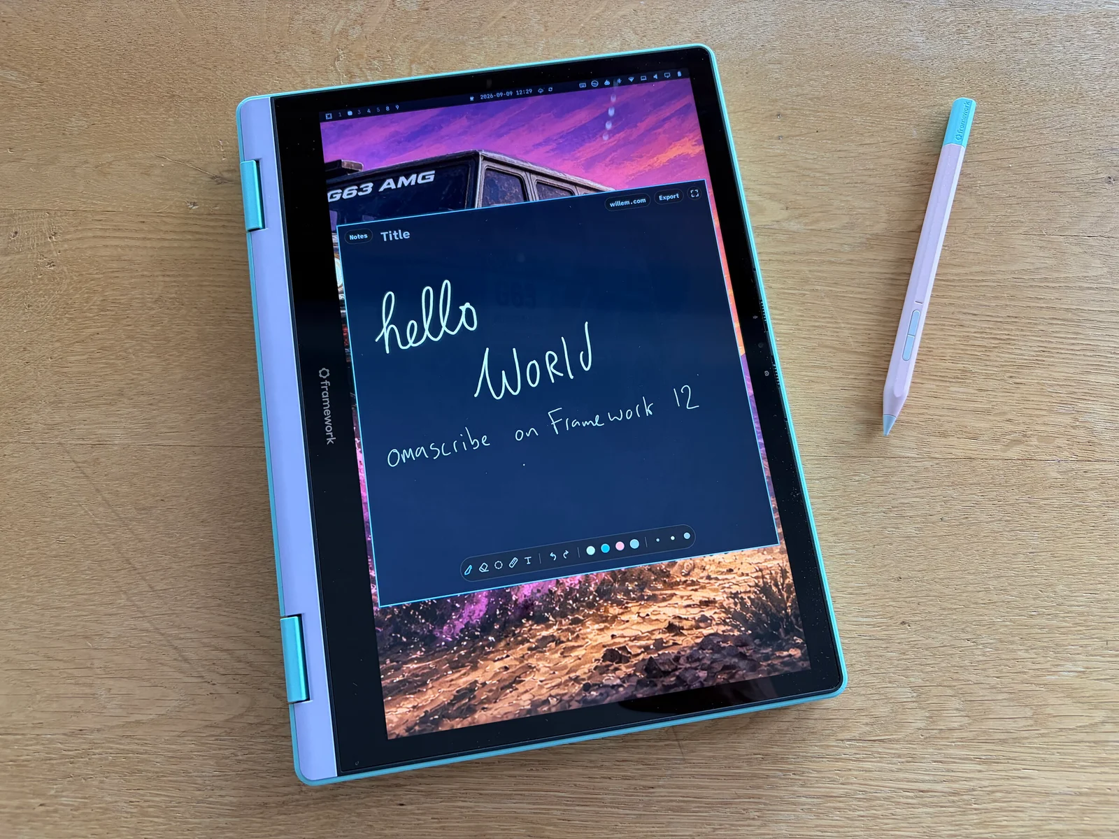 9 September: the Framework 12 folded flat on the desk, the stylus beside it, and the first thing everyone writes