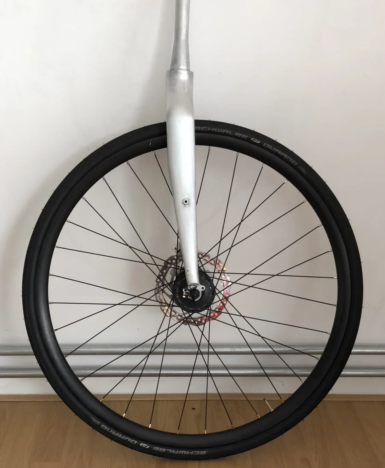 Front wheel fitted to the raw aluminium fork