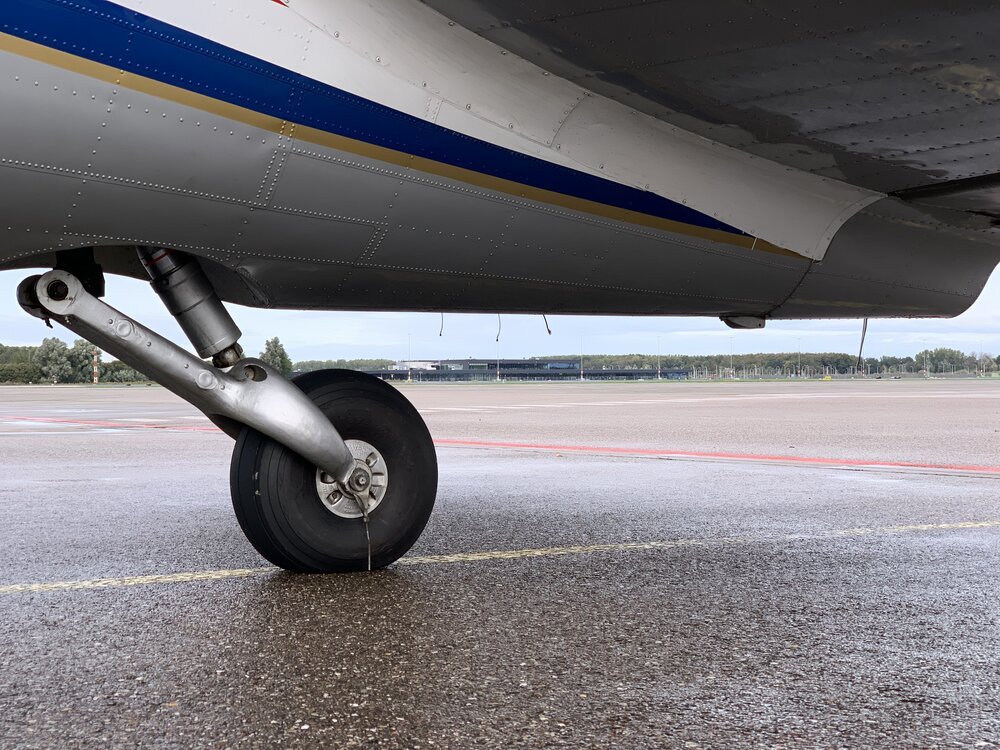 Het staartwiel van de C-47-A PH-PBA staat vrij dicht bij de grond wanneer het vliegtuig op het platform geparkeerd staat