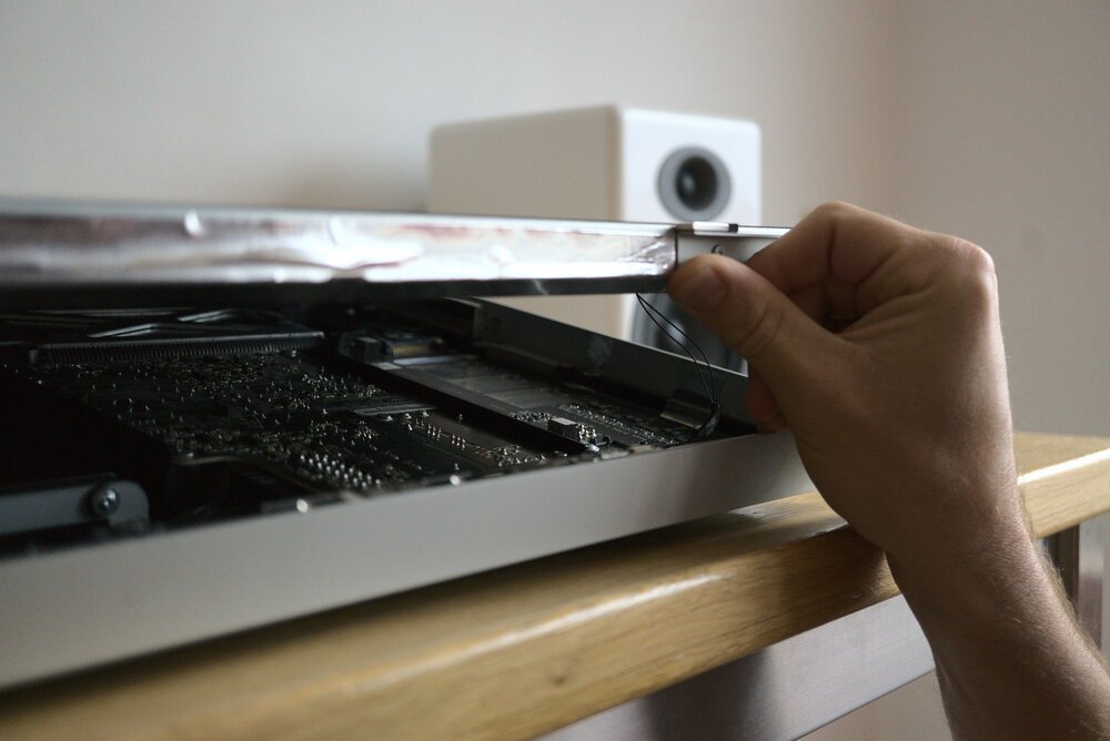 Wees voorzichtig bij het optillen van het scherm, want er zijn meerdere kabels aan het moederbord bevestigd